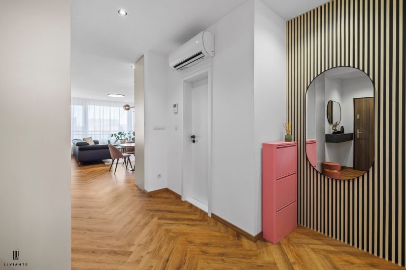 Entrance hall with wood-patterned flooring, a mirror, and a pink shoe cabinet in a 3-room apartment.
