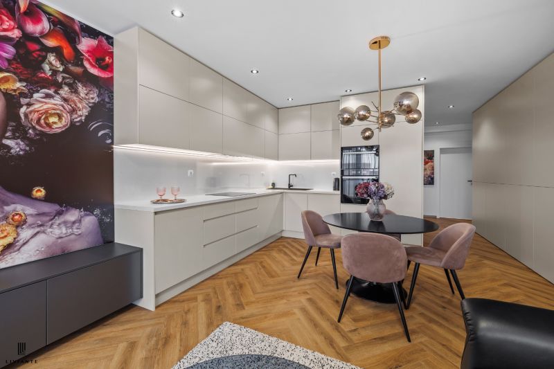 A kitchen in a 3-room apartment with a wooden decor floor and a dining table.