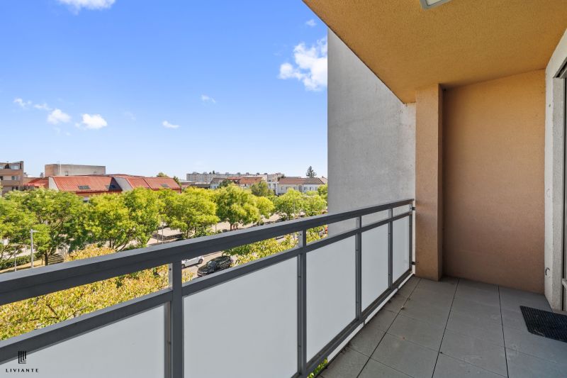 A balcony with a view of greenery and rooftops at Námestie 1. mája in Senec from a 3-room apartment.