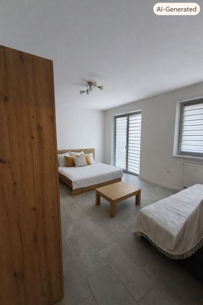 A room with a bed, a table, and a floor with a wooden decor in a studio apartment.