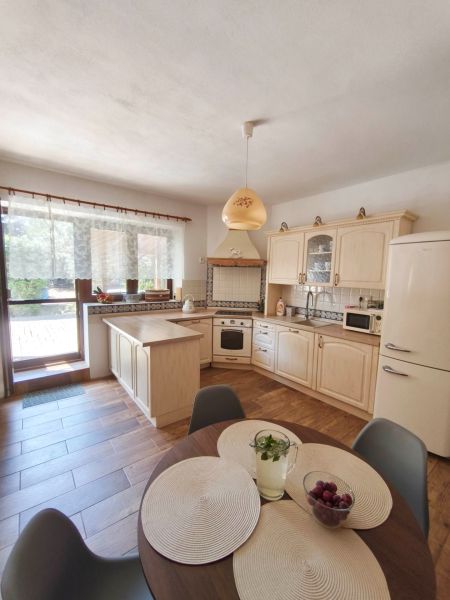 A kitchen in a family house with a wooden decor floor and light furniture.