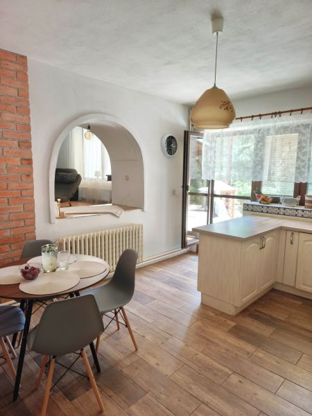 A dining room in a family house with a vaulted opening and a wooden decor floor.