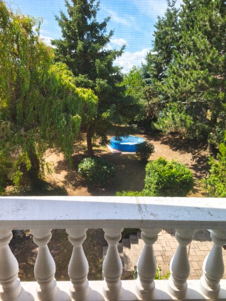View from a family house in Mankovce to a green garden with a swimming pool.