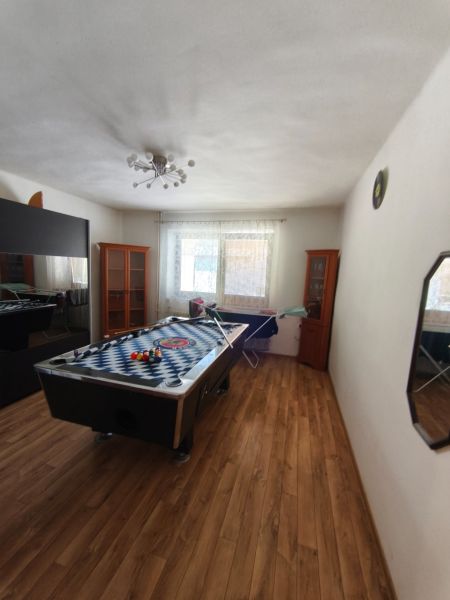 Family house with a billiard table, wood-decorated flooring, and a bright room.