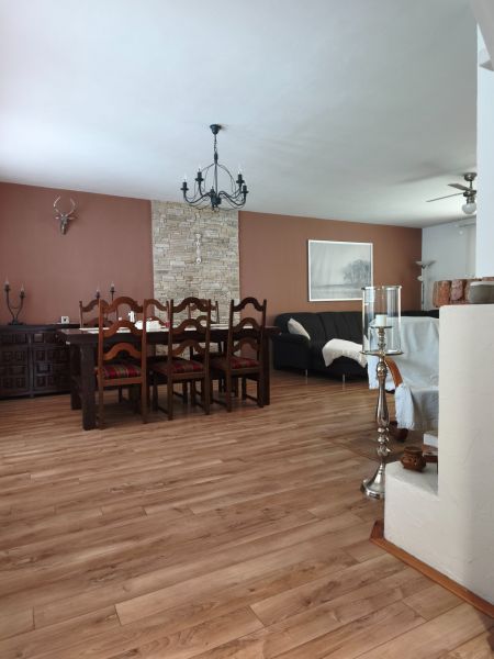 Dining room in a family house with a wooden decor floor and solid furniture.