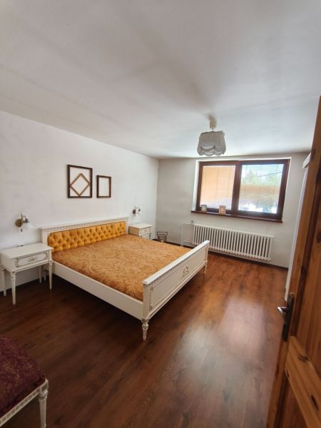 Bedroom with a bed and wood-decor flooring in a family house.