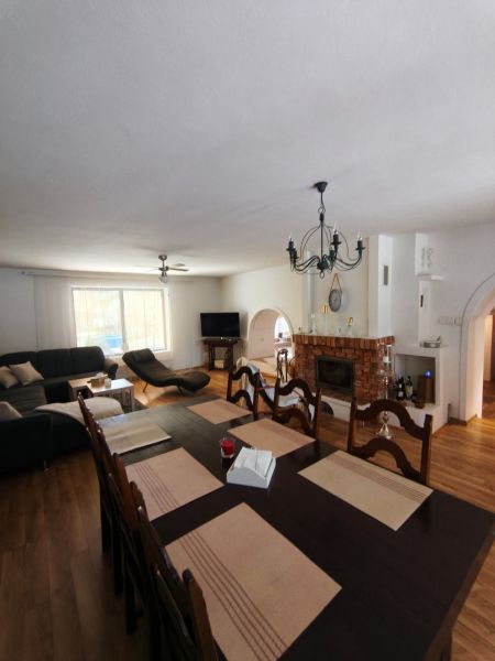 Living room with a fireplace in a family house and a floor with a wooden decor.
