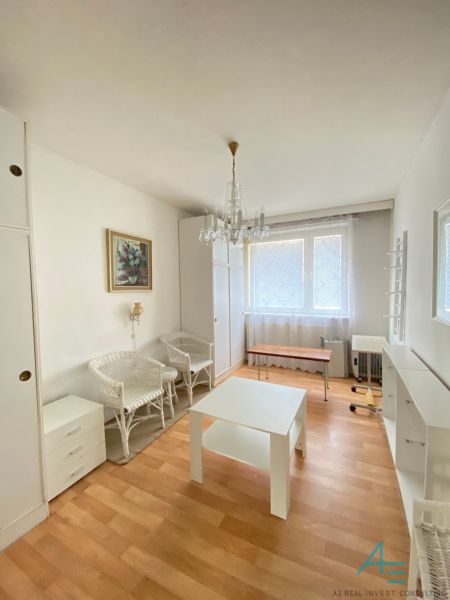Living room with light furniture and wood-patterned flooring in a 4-room apartment.