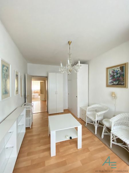 A living room with light furniture in a 4-room apartment and a floor with a wooden decor.