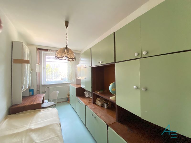 A student room with a massive wardrobe and a desk in a 4-room apartment.