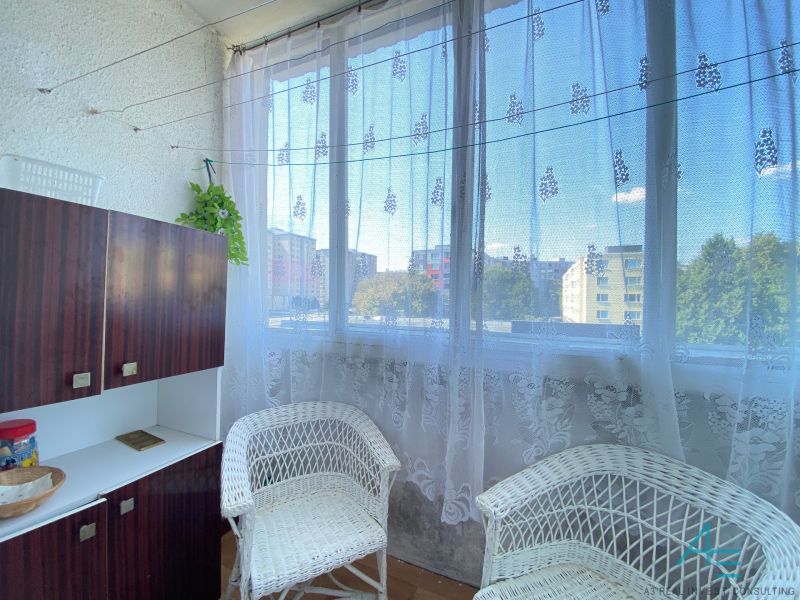 A balcony with knitted chairs and a cabinet in a 4-room apartment.
