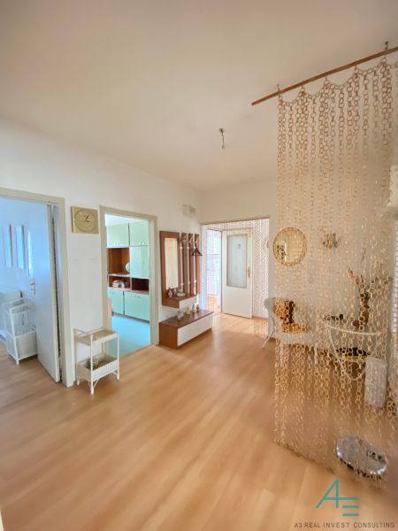 Interior of a 4-room apartment with a wood-patterned floor and a chain curtain.