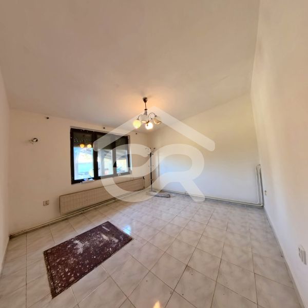 Living room in a family house with tiles and windows.