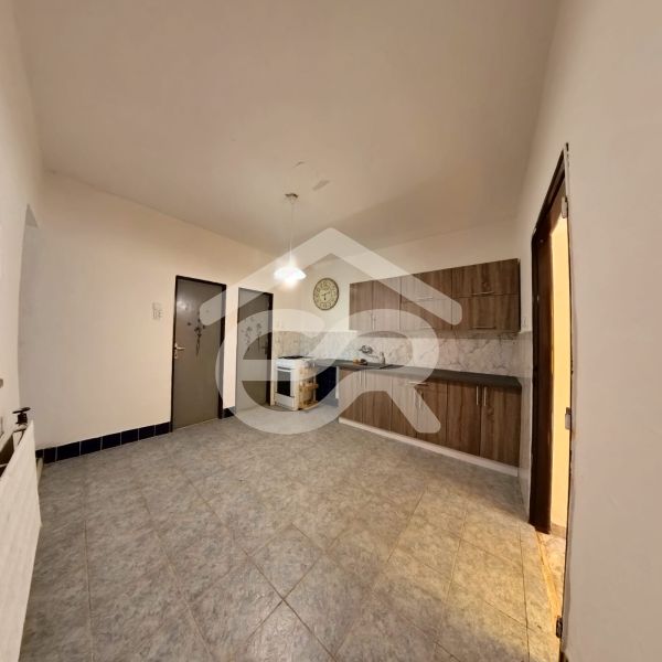 A kitchen in a family house with a floor and wooden kitchen cabinets.