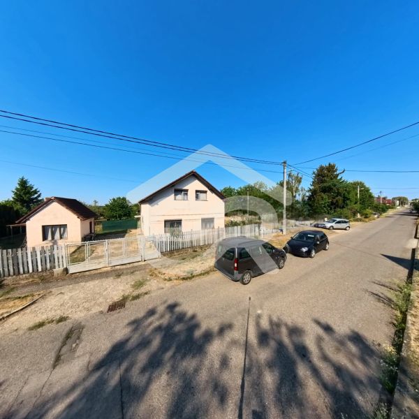 A family house on Prenosilova Street in Mojmírovce with a fence and parked cars in front of the house.