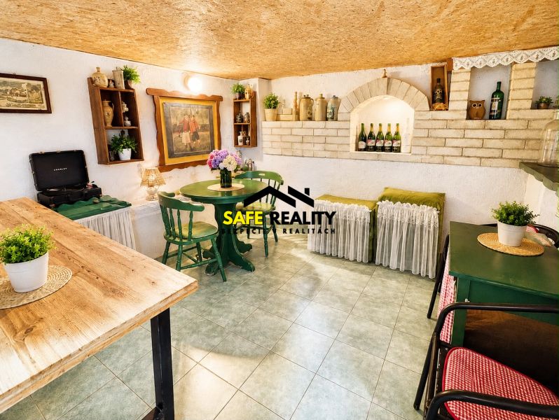 Corner in a chat with a rustic table, green chairs, and decorations.