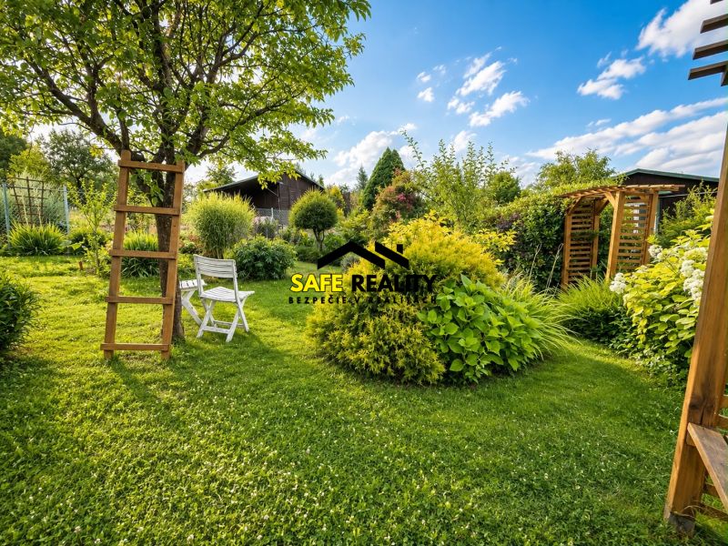 A garden by the cottage in Žilina, with a gazebo, a chair, and plenty of greenery.