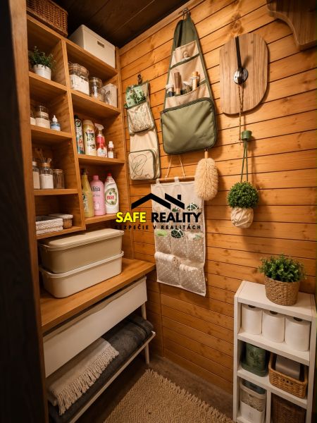 A cozy pantry in a log cabin with practical shelves, an organizer, and decorative plants.