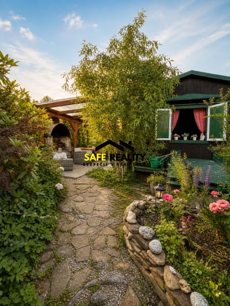 A garden by the cottage in Žilina with stone paths and a flower bed.