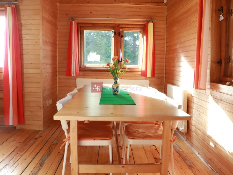 Wooden paneling, table with flowers, floor with wooden decor, and colorful curtains, Cottage.