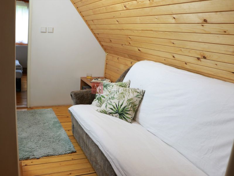 A comfortable sofa with a decorative pillow in a cozy cabin with wooden decorations.