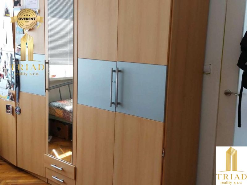A wardrobe with a wooden decor floor in a studio apartment.