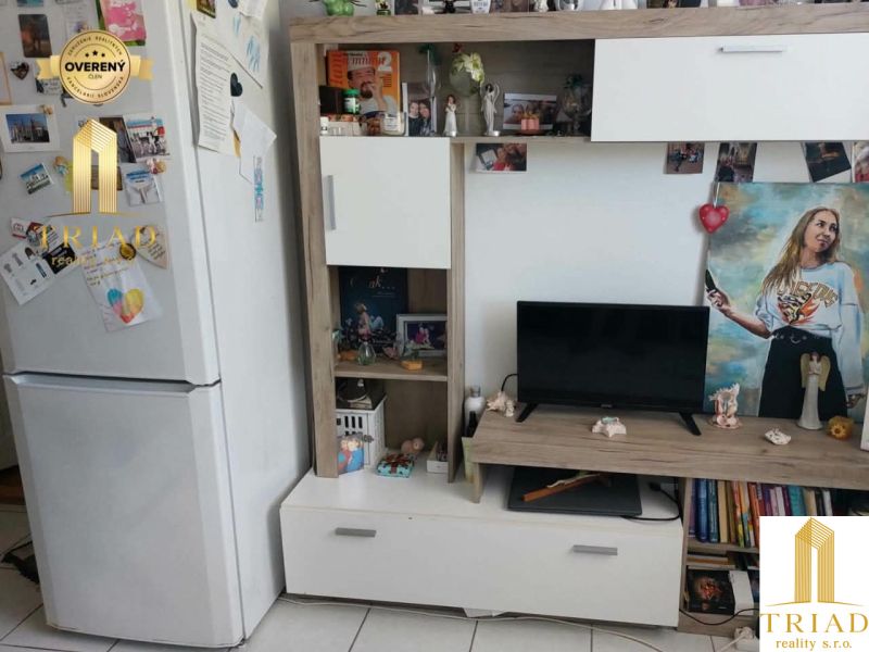Living room in a studio apartment with white furniture and decorations.