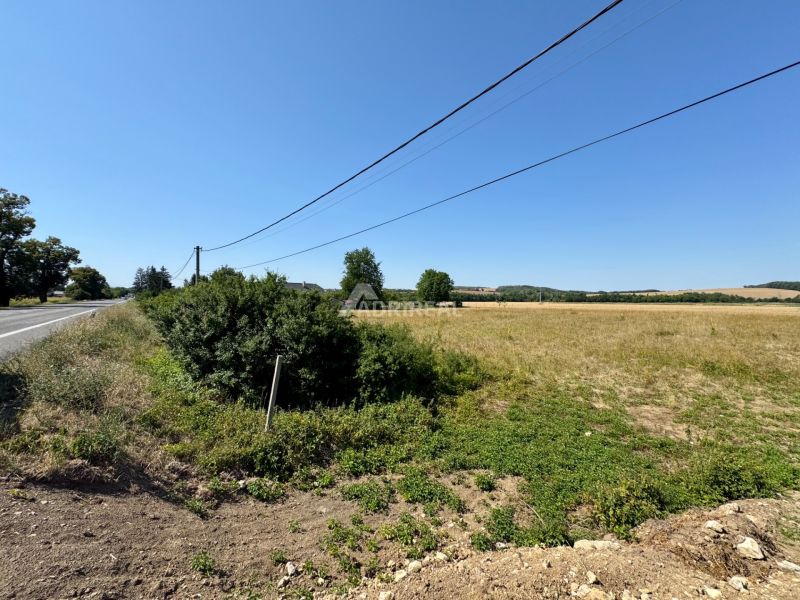 Residential plots in Hokovce, next to the road, with electrical lines above them.