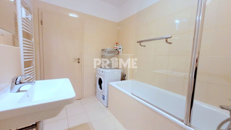 Bathroom with a bathtub, sink, washing machine, and vents in a 2-room apartment.