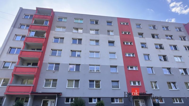 A six-story apartment building in Utekáč with balconies and colored sections of the facade.