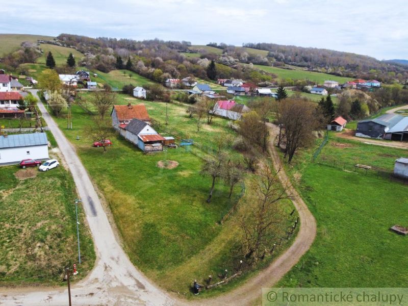The rural landscape around a family house in the village of Volica, visible road and meadow.