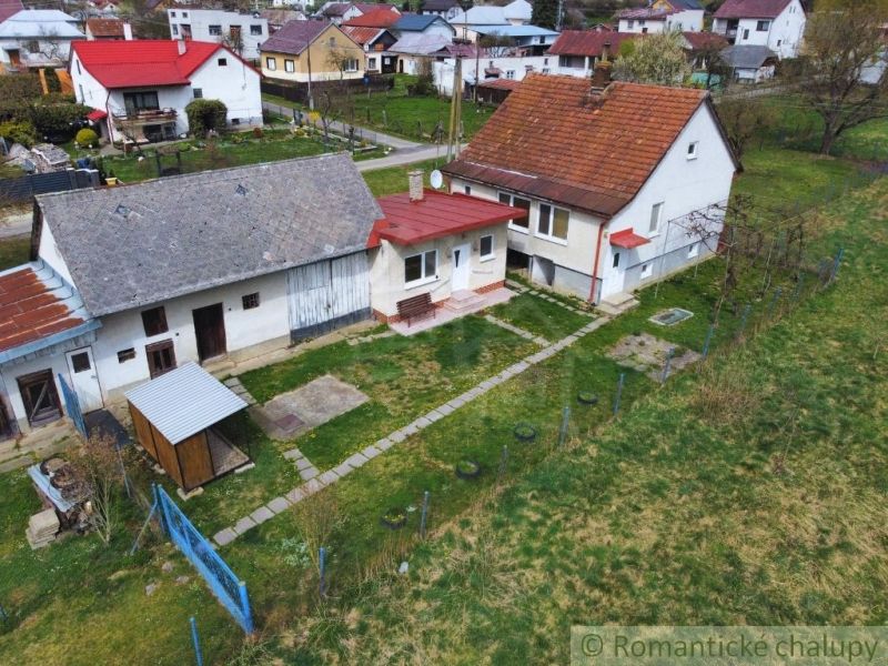 A family house in Volica with a courtyard, an annex, and a garden, surrounded by other houses.