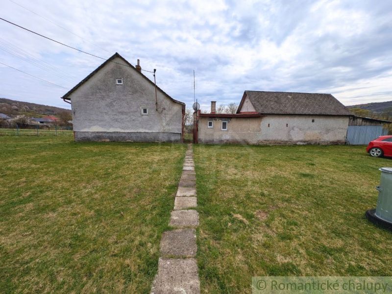 A family house in Volica with a lawn and an access path made of stones.