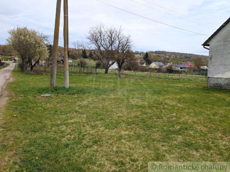 A grassy plot near a family house in Volica with a view of the surrounding countryside.