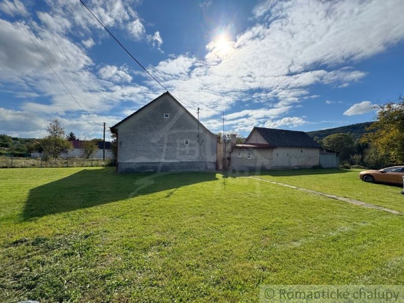 A family house in Volica surrounded by a green lawn and blue sky.