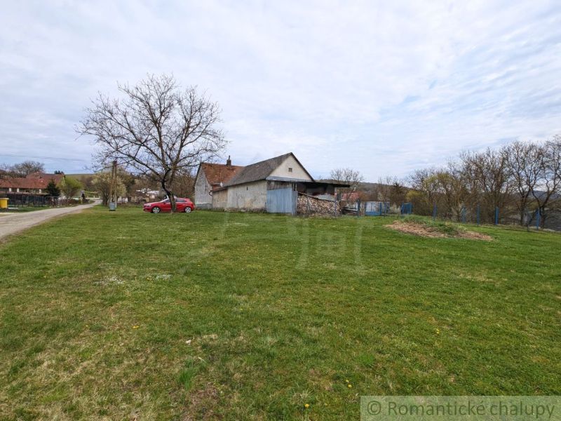 A family house in the village of Volica with a grassy plot and trees in the background.
