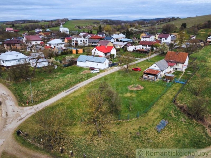 The exteriors of family houses in Volica with rural architecture on green hills.