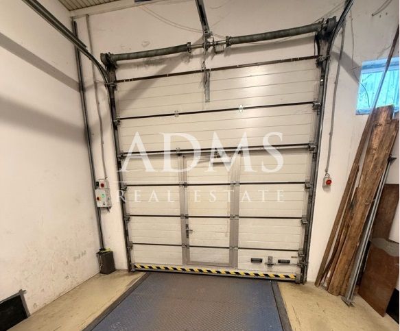 Warehouses and halls with a sectional door and flooring with a wood decor.