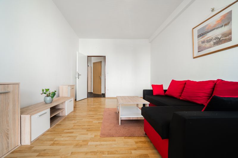 Living room with a sofa, wooden floor decor, bright interior, 2-room apartment.