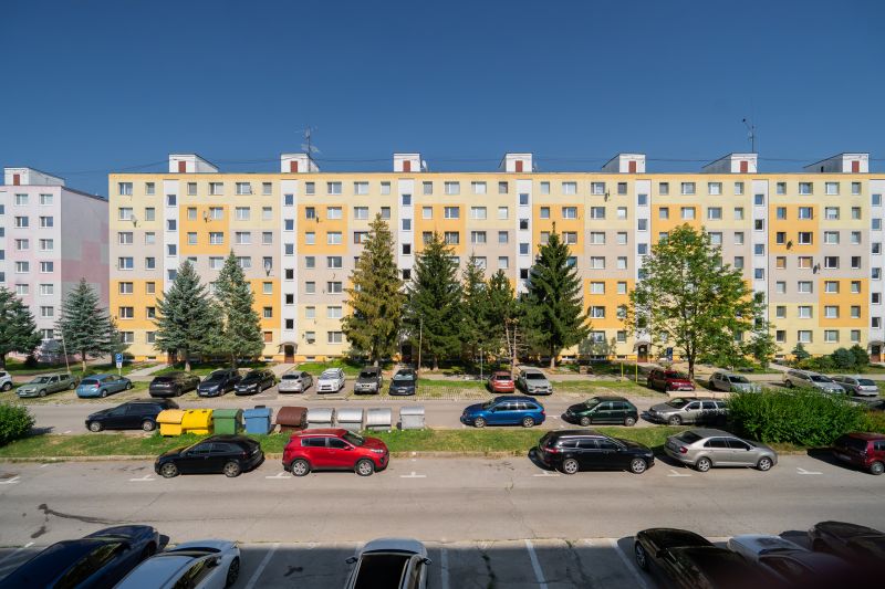 Housing estate with panel buildings and cars on the street of the May Uprising of the Czech People in Brezno.