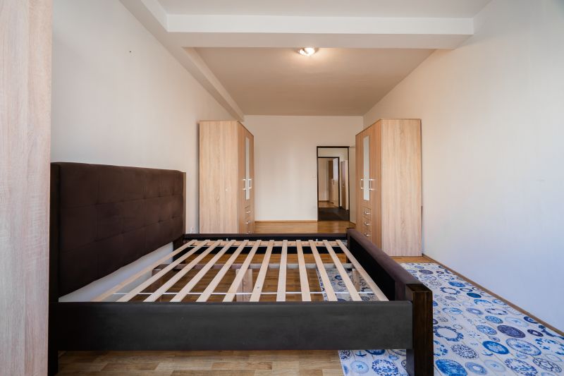 A bedroom in a 2-room apartment with an empty bed and wardrobes.