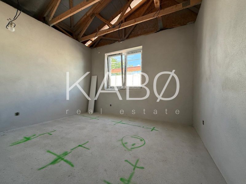 Interior of a family house with an unfinished ceiling structure and drawings on the floor.