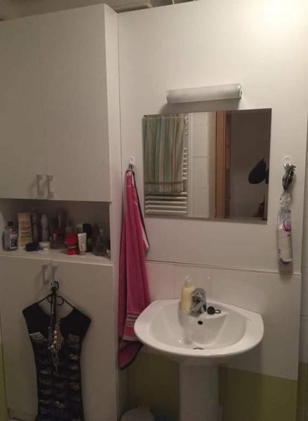Bathroom of a 2-room apartment with a sink, mirror, and storage space.