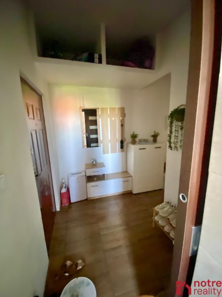 Entrance hallway of a one-room apartment with a wooden decor floor and storage space.