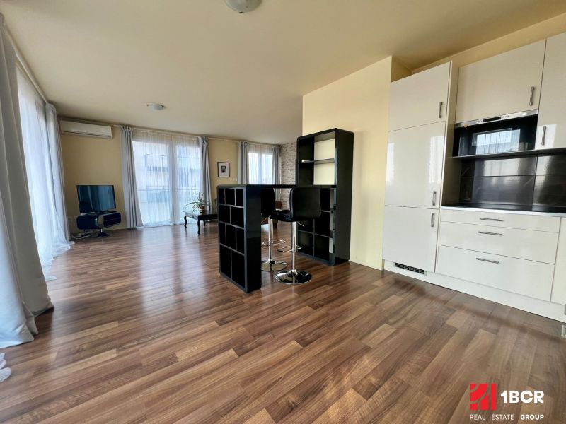 2-room apartment with wood-patterned flooring and a white kitchen unit.