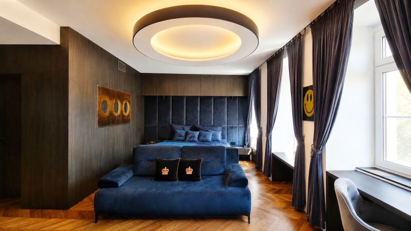 Luxury room with blue furniture, wood-patterned flooring, and a large window.