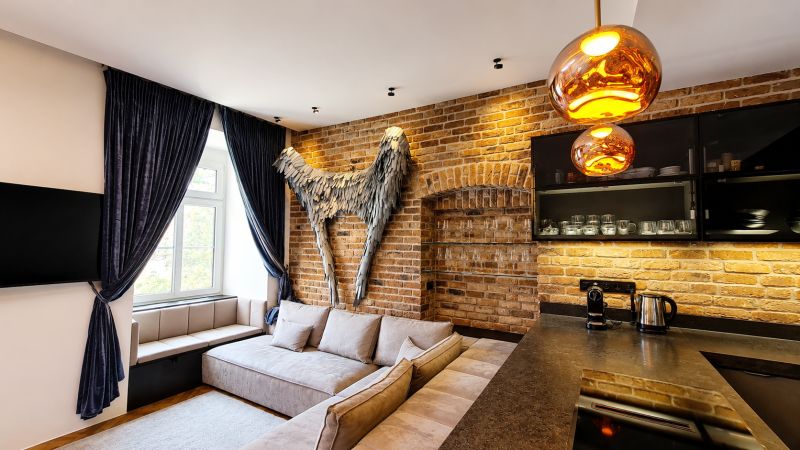 Design interior of a 2-room apartment with a brick wall and a comfortable sofa.