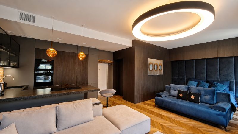 Living room in a two-room apartment with a wooden decor floor and interesting lighting.