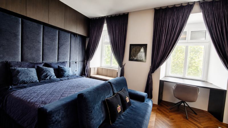 Luxury bedroom with dark curtains and a desk in a 2-room apartment.