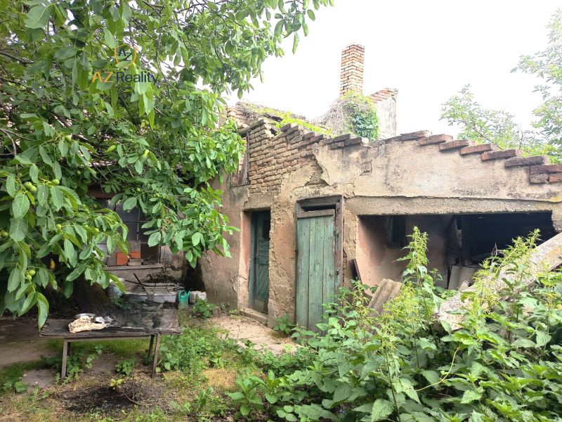 An old family house in Nové Zámky with a neglected garden and a damaged roof.